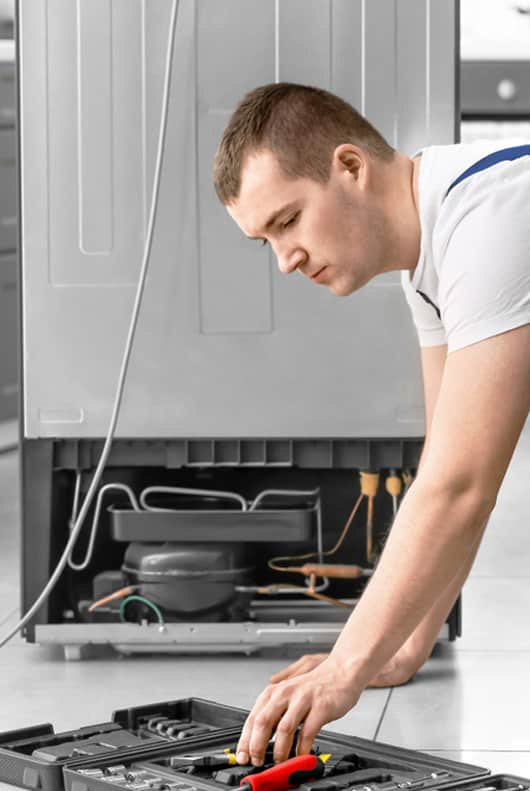 Male Technician Repairing Refrigerator - Alpine Refrigeration & Air Conditioning In West Wallsend,NSW