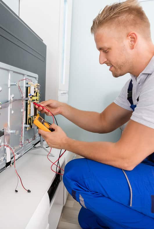 Electrician In Overall Checking Television- Alpine Refrigeration & Air Conditioning In West Wallsend,NSW