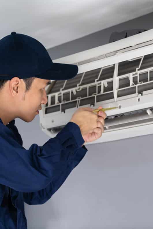 Technician Repairing An Air Conditioner - Alpine Refrigeration & Air Conditioning In West Wallsend,NSW